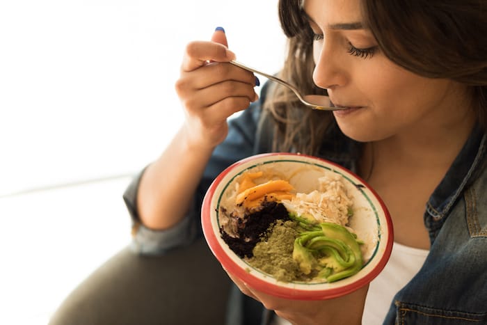 Woman eating a vegan bowl of superfoods