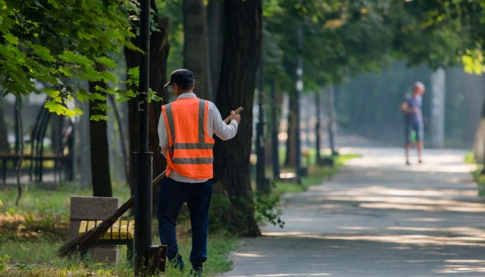 A park employee clearing the trail of overgrowth and leaves to keep it clean for visitors.