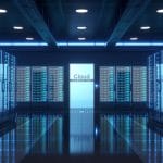 The interior of a data center with multiple rows of brightly-lit server racks and a door in the middle that says "Cloud".