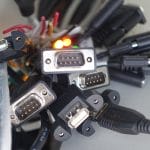 A close-up view shows several cables with various connectors grouped together. The cables are all black.